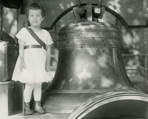 Little girl standing next to Liberty Bell along the Justice Bell tour.