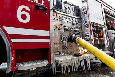 Icicles hang from fire truck hose.