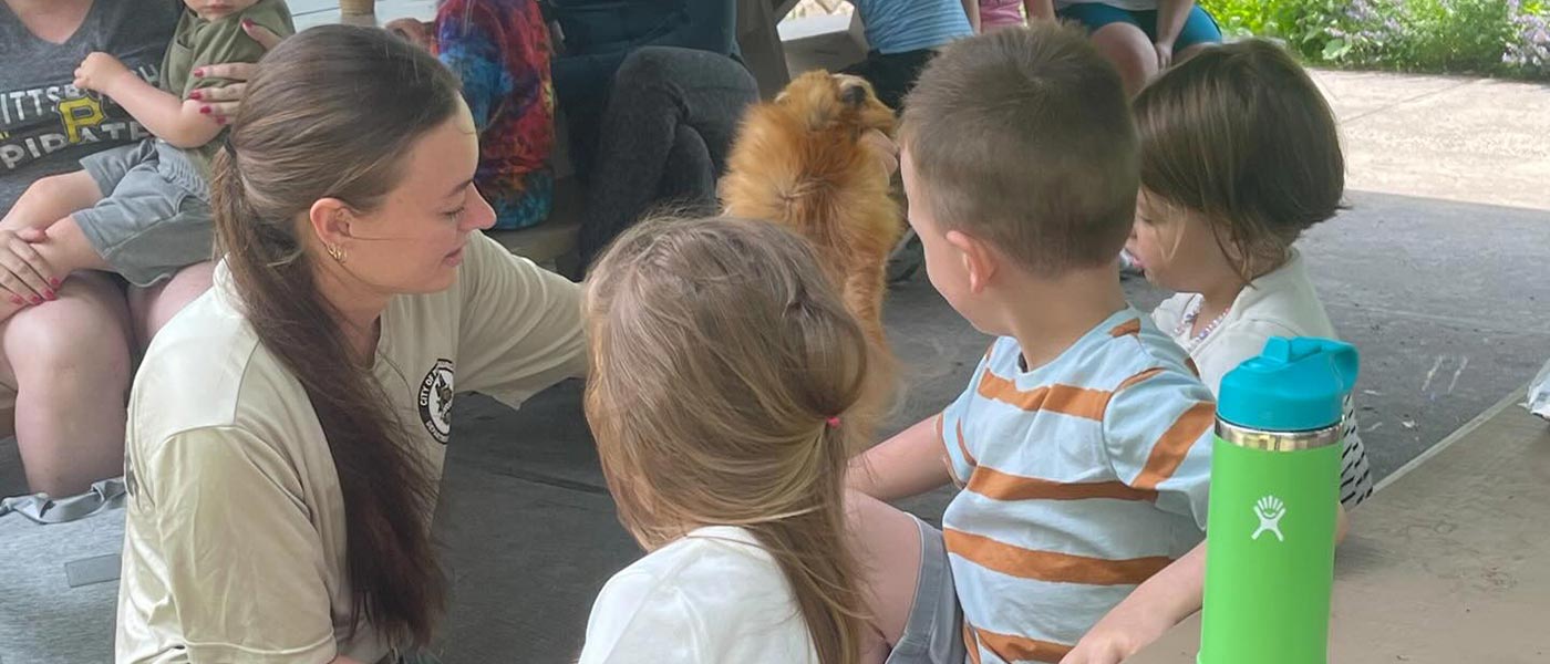 Park Ranger showing young children an animal fur.