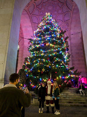 2025 Tree Lighting - illuminated with two women posing for photo with Santa.
