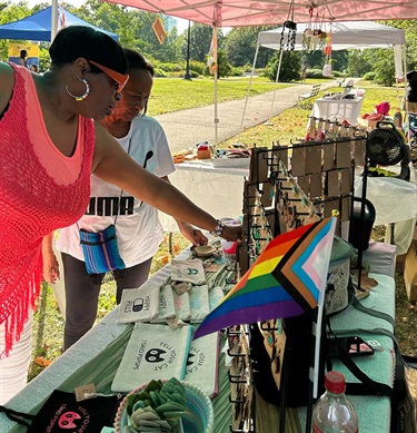 Two women looking items in a sales booth.
